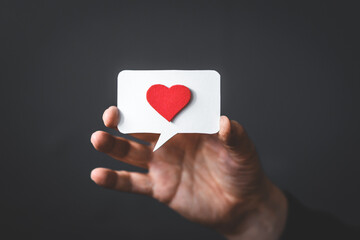 Speech Bubble with Red Heart in Mans Hand on Dark Background Copy Space Positive Feedback and Review Concept