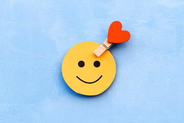 yellow happy smiley face on a blue background and a red heart as the emotion selection. The concept...