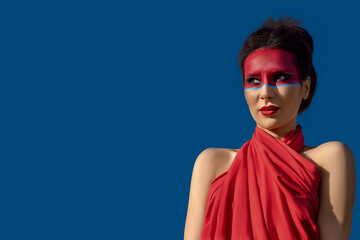 Portrait of a beautiful young brunette woman with creative makeup on her face
