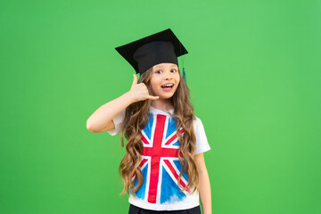 The graduate shows a hand gesture that she is calling on the phone. a joyful schoolgirl with curly...
