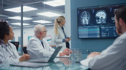 Hospital Conference Meeting Room: Neurologist Shows MRI scan, Magnetic Resonance Image on TV Screen, Team of Neuroscientists, Doctors Discuss Patient Treatment, Drug Research, Medicine Development