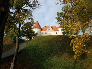 Obraz premium Old Latvian castle in the town of Bauska among trees with yellowed leaves October 16, 2020