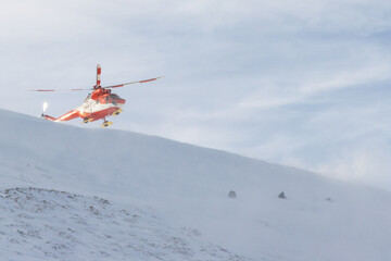 Tatra Mountains. Red and white rescue helicopter,  flying over Kasprowy Wierch and Swinica in High...