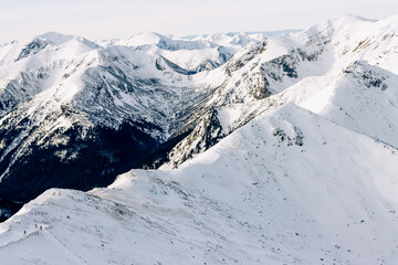 Fototapeta na wymiar Tatra mountians at winter time. View of the white snow-capped peaks, frosty winter mountains. Kasprowy Wierch, High Tatra, Poland, Europe.