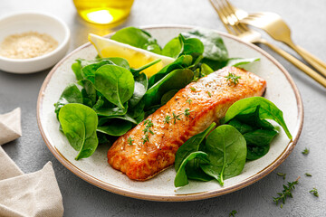 Grillet salmon and fresh spinach salad dressed with lemon