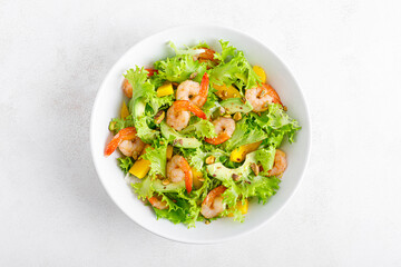 Grilled shrimp salad with avocado, mango, lettuce and pistachios, dressed with lime. Healthy food. Ketogenic diet. Top view.