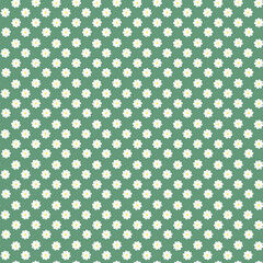 Seamless pattern with small white flowers on green background. Vector floral background. Pattern with tiny chamomiles. 