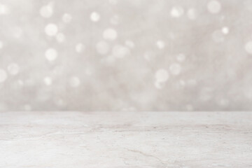 Empty brown marble table top, counter top, in the foreground, with sparkling, blurred, gold bokeh background. Perspective marble surface for product display mockups.
