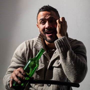 Alcoholic man with bottles wine cry. Depressed crying man. Drunk alcohol addict man drinking whiskey, depressed as alcoholic suffering alcoholism problem and alcohol addiction.
