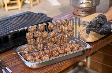 Chopped beef cutlet prepared on a barbecue. Grilling meat balls served for a dinner by a chef.
