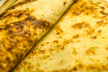 Fresh homemade pancakes on a plate close-up. Shrovetide. Pancake day. Maslenitsa. Cooked food for the holiday. Soft focus