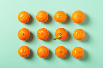Fresh clementine mandarins or tangerines on blue background with copy space, top view, flat lay	