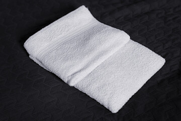 White towel lying on a black blanket