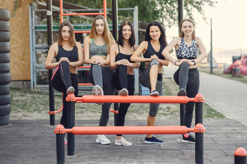 Fototapeta na wymiar Sports girls training in a summer park