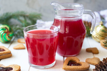 Healthy drink: cherry jelly in a glass and cherry jelly in a jug on a white table. close-up