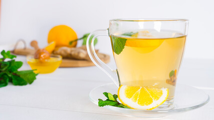 Glass cup with tea, mint and lemon