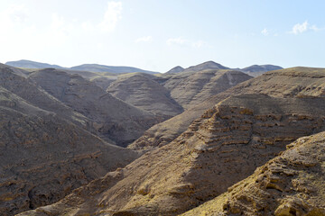 Naklejka premium Mountain landscape, desert. Stony desert panoramic view. Unique relief geological erosion land form. Stone Desert on the West Bank. Judean Desert in clear weather. 