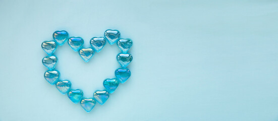 Glass hearts on a blue background. Valentine's day greeting, wedding and invitation concept.