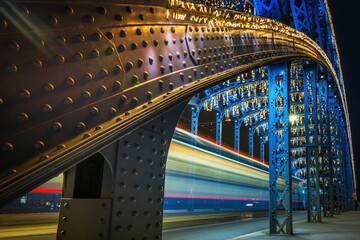 Rozpędzony tramwaj przejeżdżający przez stalowy most - obrazy, fototapety, plakaty