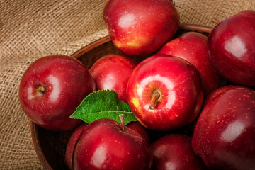 Ripe red apples in a bowl on the table.