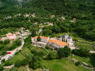 Fototapeta na wymiar Podmaine monastery surrounded by green trees. Top view