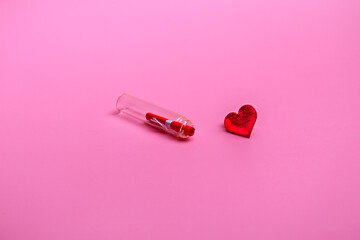 Message in a bottle on a pink background with a heart. Holiday concept. Closeup with copy space