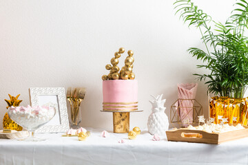 Holiday birthday table with cake and ballons. Pink and golden decoration