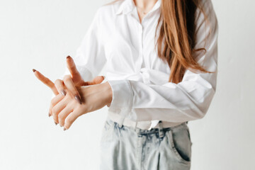 Woman in white shirt spreading hand cream over her hand. Close up. cold season hands skin protection. closeup woman applying protective cream on hands.