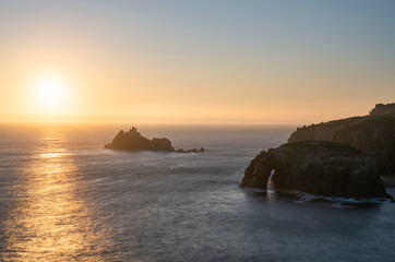 Land's End with Enys Dodman arch sunset in Cornwall. United Kiongdom