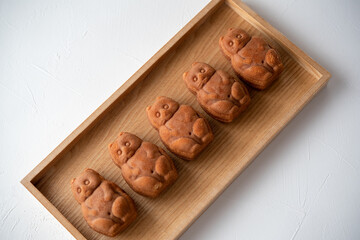 木のトレイに5つ並んだたぬきの人形焼き