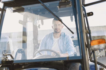 Male sitting comfortably on a big blue tractor