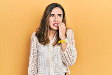 Young hispanic girl wearing casual clothes looking stressed and nervous with hands on mouth biting...
