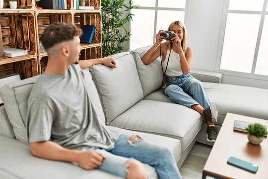Woman making photo to her boyfriend using camera at home.