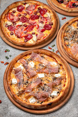 Pizza party dinner. Flat-lay of different kinds of Tasty hot Italian pizza on a beige textured background. Fast food lunch, gathering, celebration. Pizzeria 
