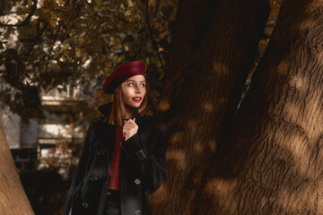 Fototapeta na wymiar Portrait of a brunette woman leaning on a tree.