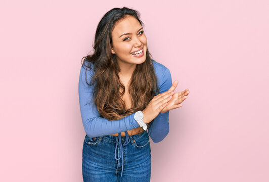 Young hispanic girl wearing casual clothes clapping and applauding happy and joyful, smiling proud hands together