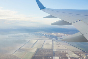 Fototapeta premium View to the wing of airplane in the sky. Travel and transportation concept