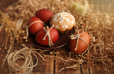 Easter eggs and cupcake on a dark wooden background. Selective focus, top view