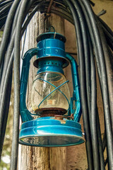 a rustic blue lantern hanging on the homestead in Alaska
