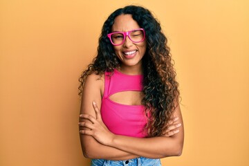 Young latin woman wearing casual clothes and glasses winking looking at the camera with sexy...