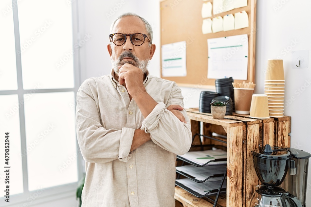 Wall mural Senior grey-haired man standing with arms crossed gesture at office