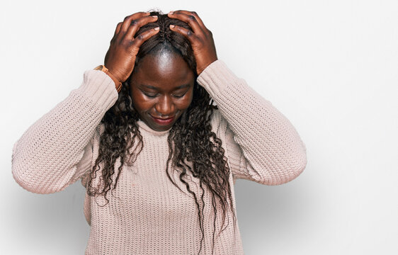 Young african woman wearing wool winter sweater suffering from headache desperate and stressed because pain and migraine. hands on head.