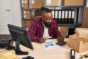 Young african american man ecommerce business worker counting dollars at office