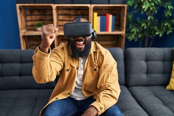 Young african american man playing video game using virtual reality glasses at home