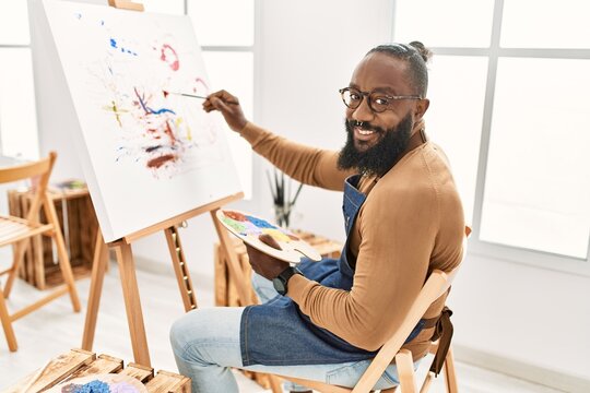 Young african american artist man smiling happy drawing at art studio.