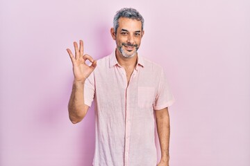 Handsome middle age man with grey hair wearing casual shirt smiling positive doing ok sign with hand and fingers. successful expression.