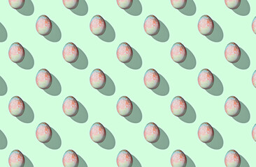 Pattern of easter eggs on green pastel background