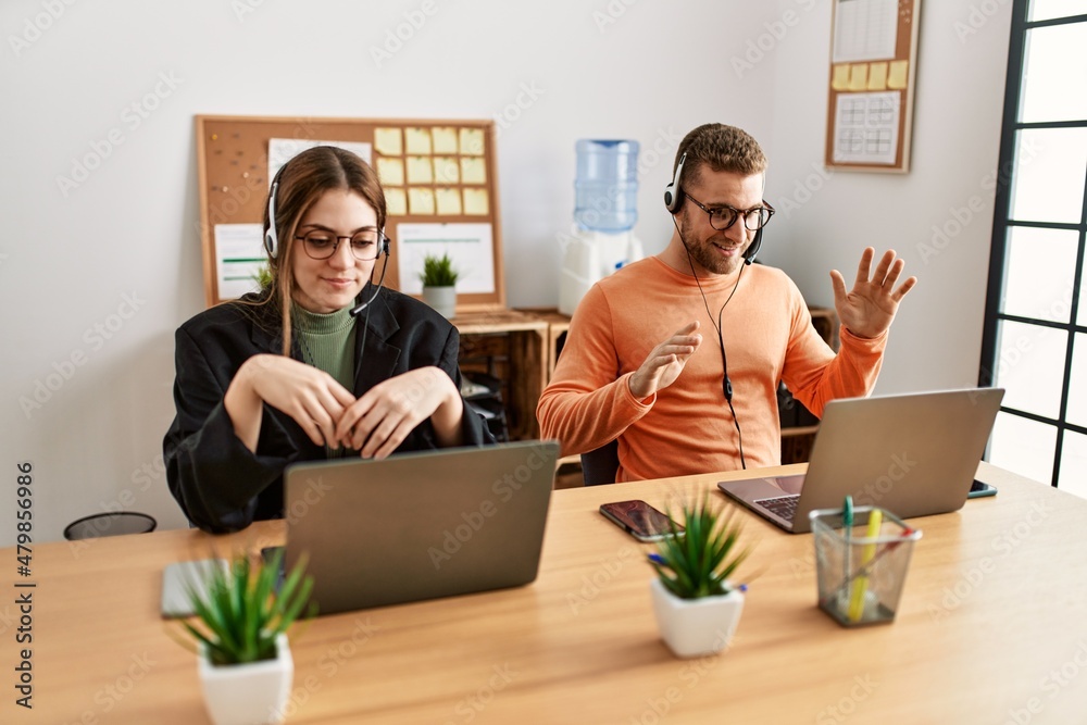 Wall mural Two caucasian call center agents working at the office.