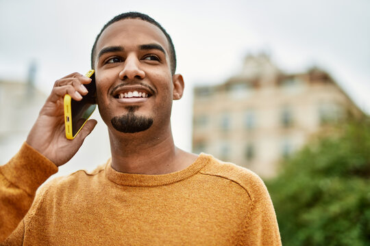 Young african american man smiling happy talking on the smartphone at the city.