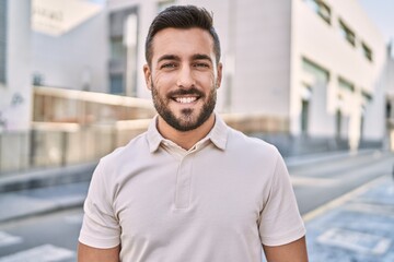 Young hispanic man smiling confident walking at street